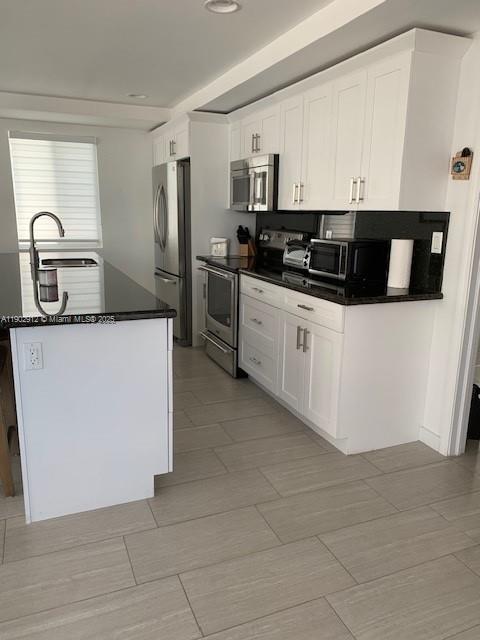 94825 Overseas Highway, Unit 172 Key Largo, FL 33037 - Photo 6 of 40 a kitchen with stainless steel appliances a sink a stove a microwave a sink a refrigerator and cabinets