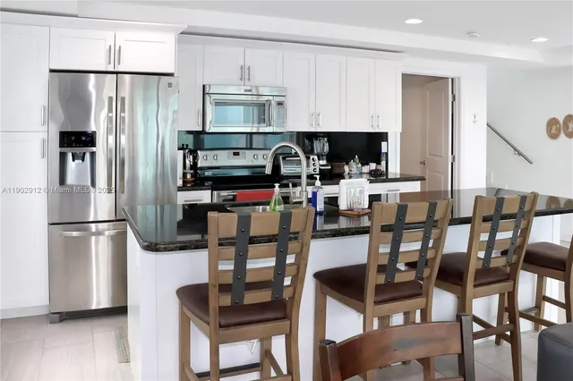 a kitchen with stainless steel appliances granite countertop a refrigerator and a stove top oven