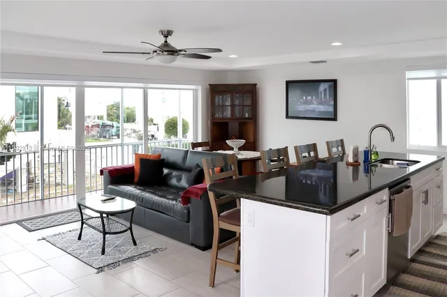 a living room with furniture a large window and a dining table