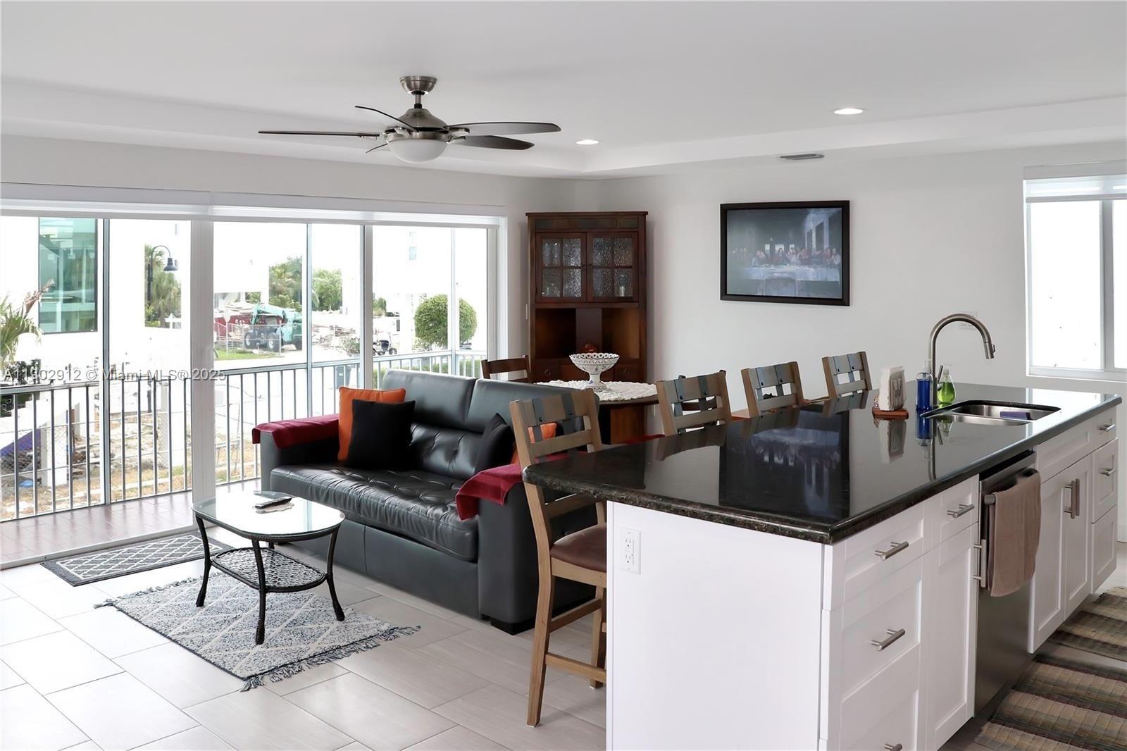 94825 Overseas Highway, Unit 172 Key Largo, FL 33037 - Photo 10 of 40 a living room with furniture a large window and a dining table
