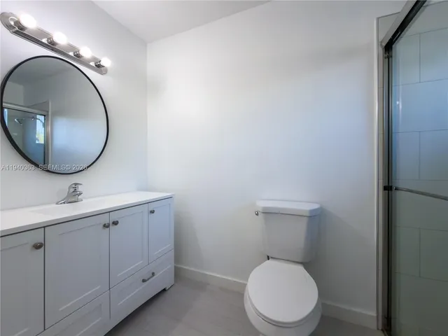 a bathroom with a toilet sink vanity and mirror