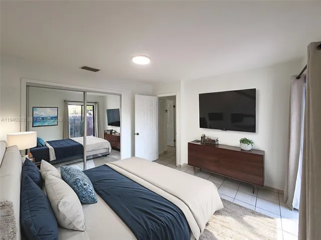 a bedroom with a bed and a flat screen tv