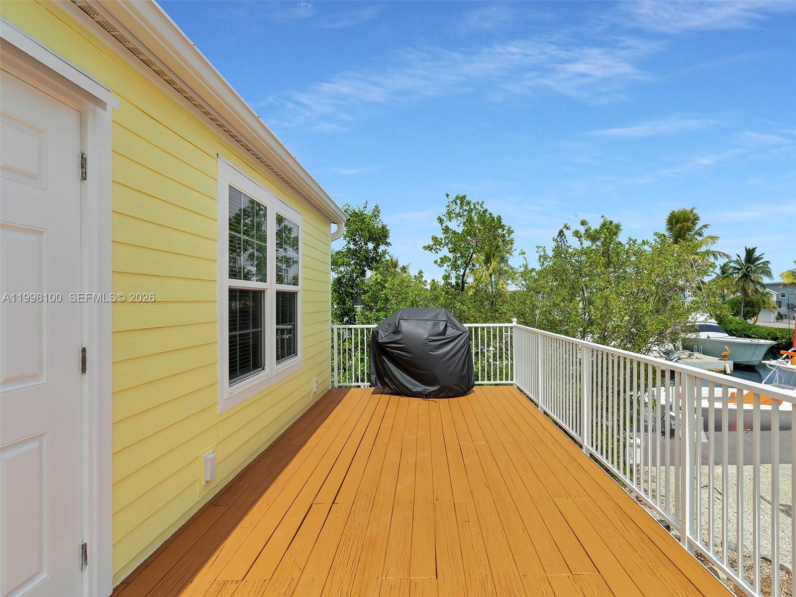 437 Pirates Road Summerland Key, FL 33042 - Photo 35 of 39 a view of a balcony with wooden floor and fence