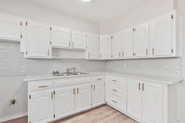 a kitchen with white cabinets and white appliances
