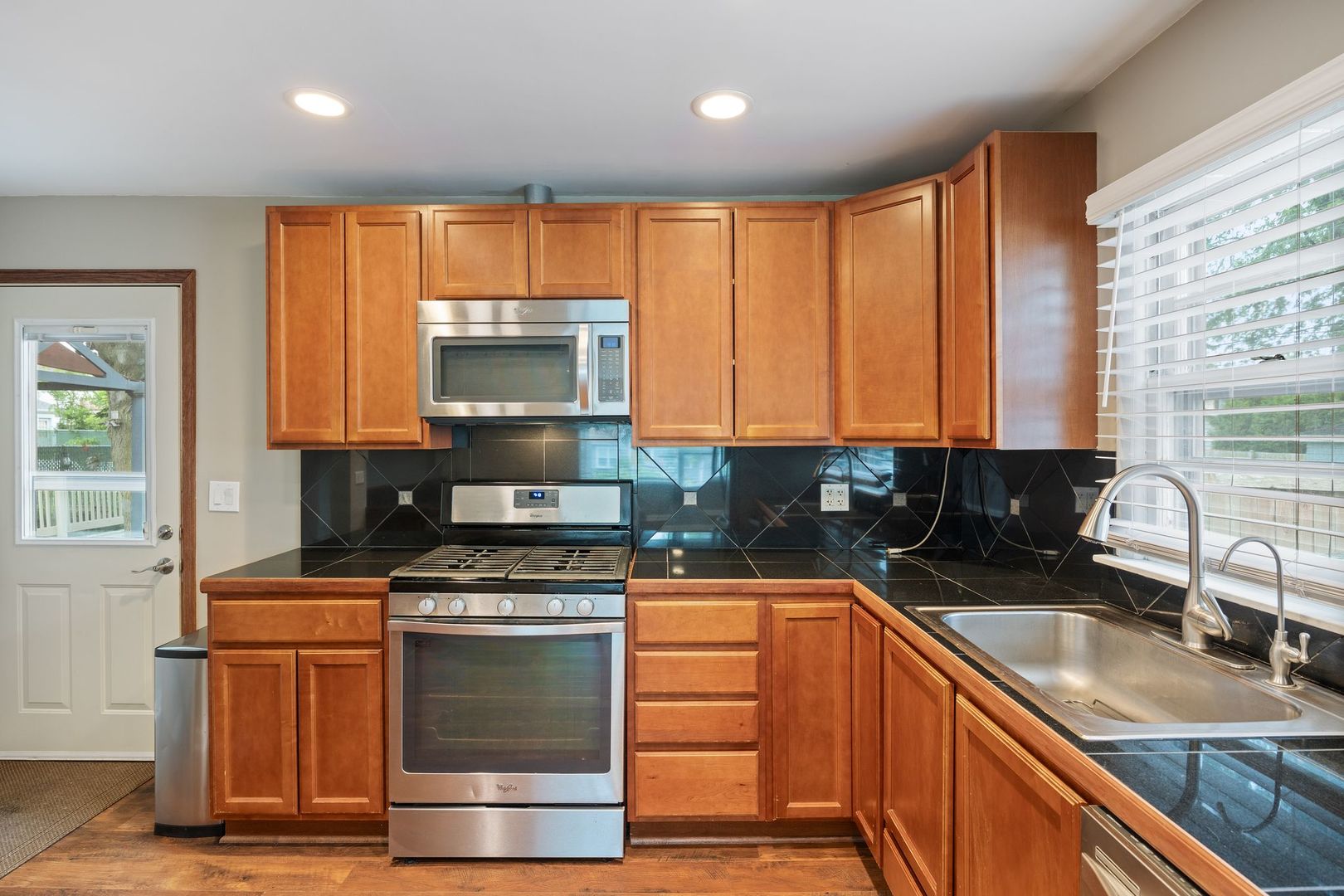 149 Wheeling Avenue Wheeling, IL 60090 - Photo 4 of 23 a kitchen with granite countertop a stove a sink and a microwave