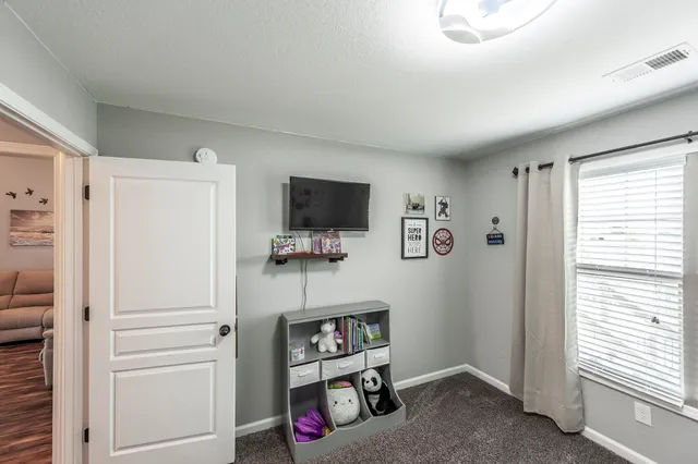 a view of room with cabinets flat screen tv and windows