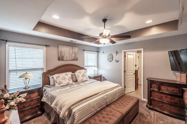 a bedroom with a bed and a flat tv screen on a dresser
