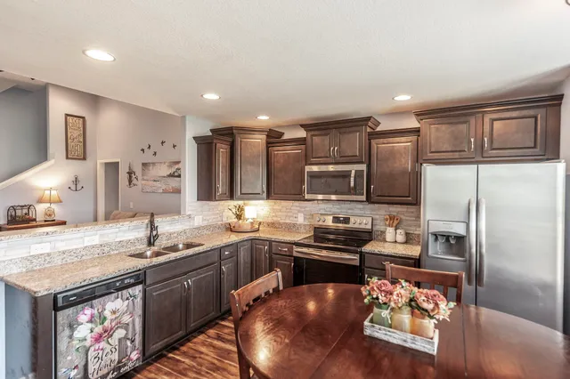a kitchen with stainless steel appliances granite countertop a sink stove and refrigerator
