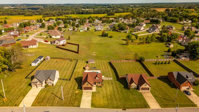 a view of pool with large trees and a yard with lawn chairs