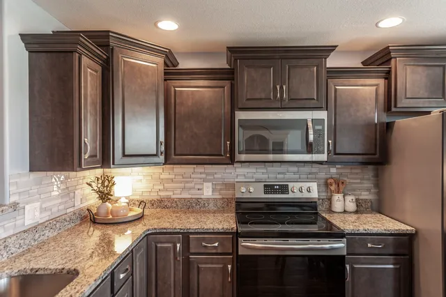a kitchen with granite countertop stainless steel appliances and wooden cabinets