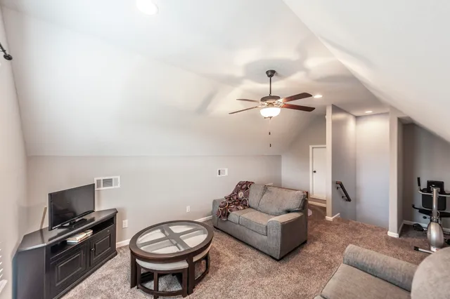 a living room with furniture a flat screen tv and a wall painting