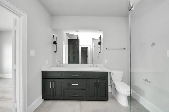 a bathroom with a sink a toilet and shower