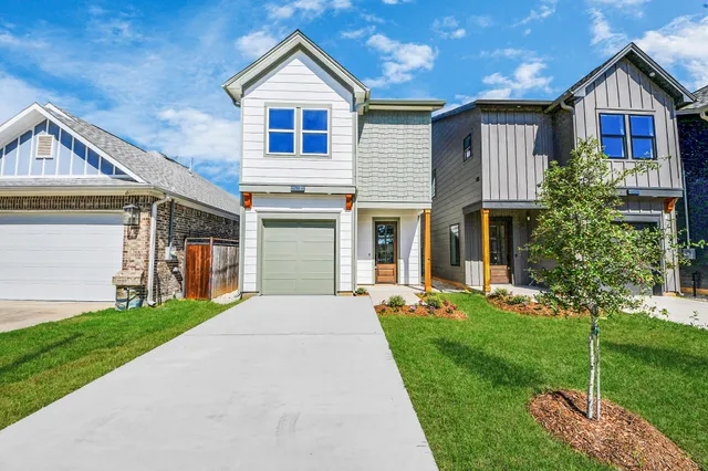 a front view of a house with a yard and trees