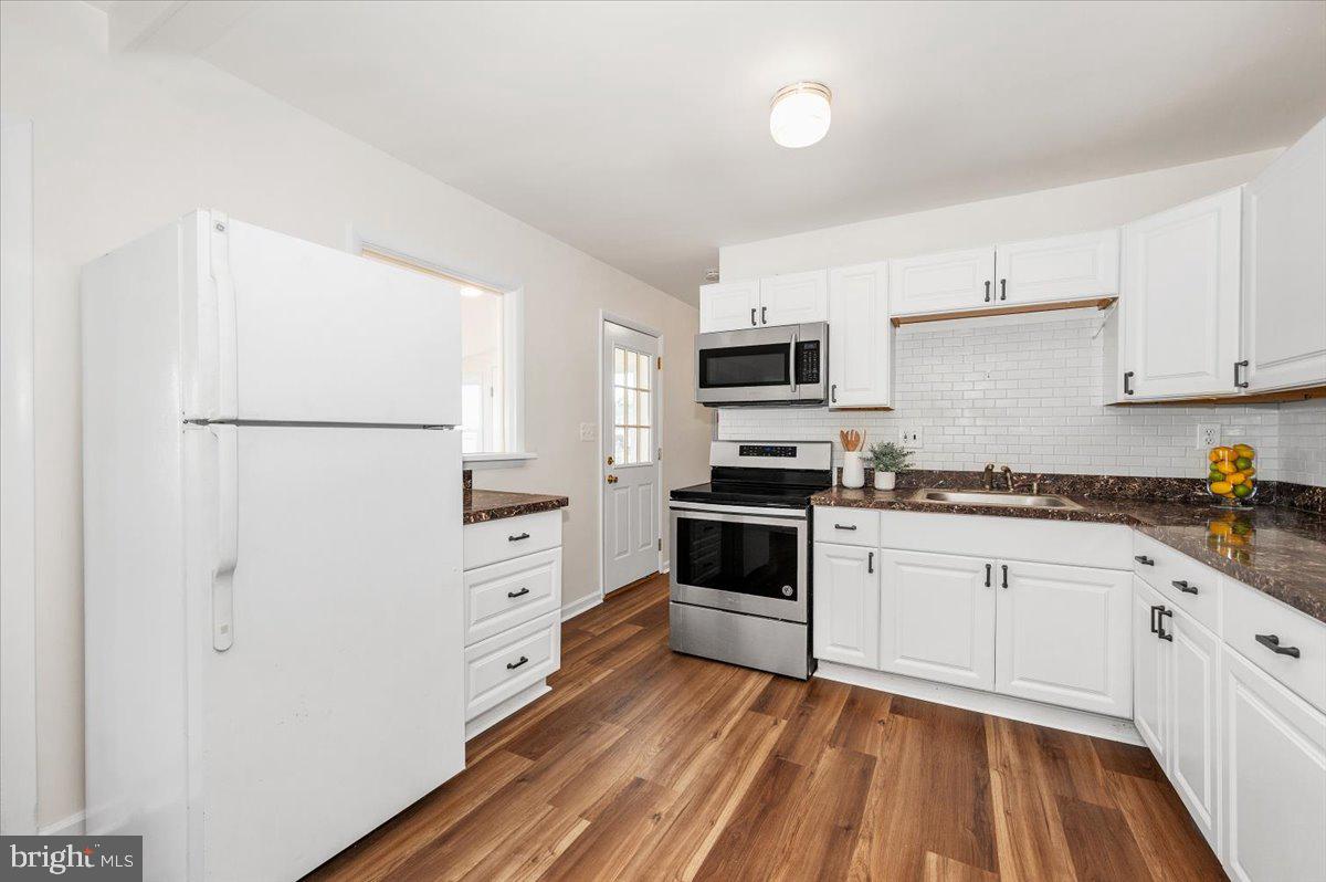 1200 Wilson Place Frederick, MD 21702 - Photo 13 of 57 a kitchen with white cabinets and white appliances