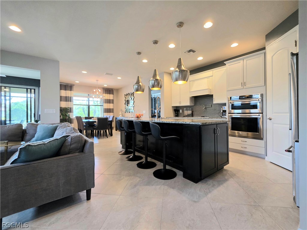 10805 Dennington Road Fort Myers, FL 33913 - Photo 11 of 45 a living room with stainless steel appliances kitchen island granite countertop a couch and a view of kitchen