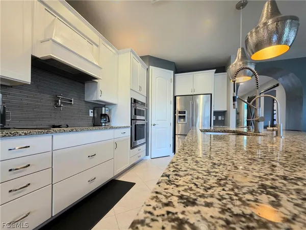 a kitchen with stainless steel appliances granite countertop a granite counter tops and a refrigerator