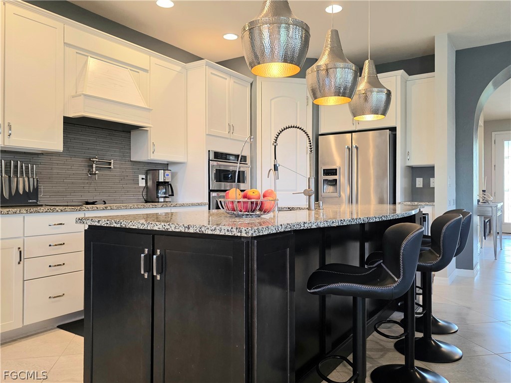 10805 Dennington Road Fort Myers, FL 33913 - Photo 23 of 45 a kitchen with stainless steel appliances granite countertop a sink a stove and chairs