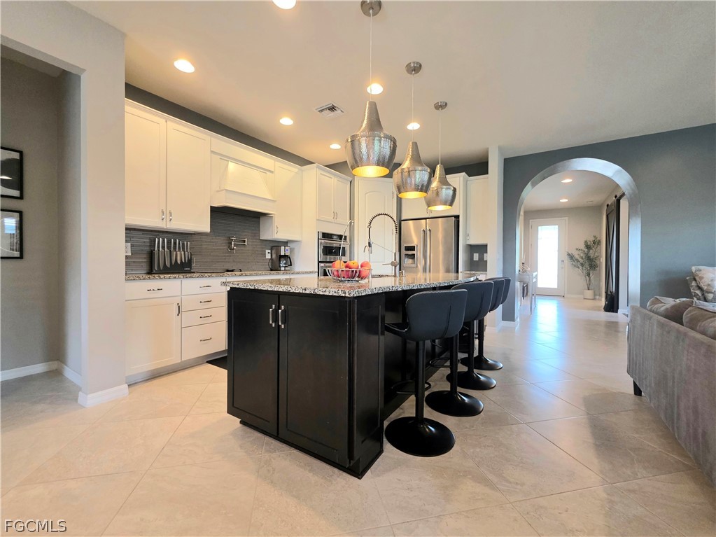 10805 Dennington Road Fort Myers, FL 33913 - Photo 24 of 45 a kitchen island with stainless steel appliances kitchen island granite countertop a sink and cabinets