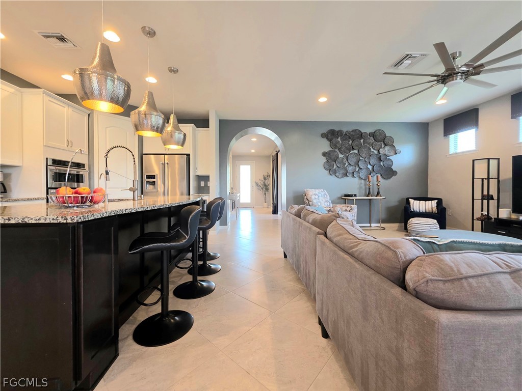 10805 Dennington Road Fort Myers, FL 33913 - Photo 31 of 45 a living room with furniture kitchen view and a chandelier