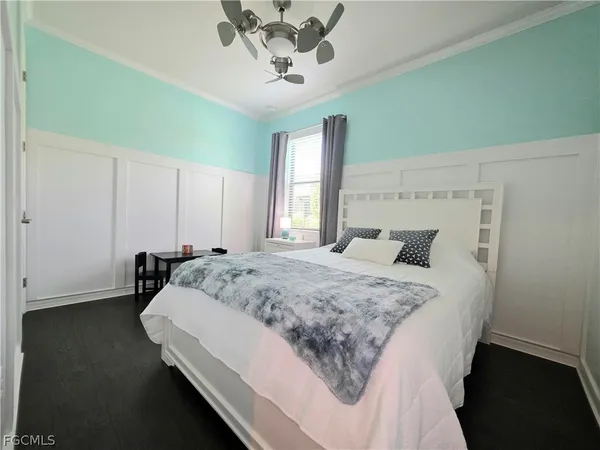 a bed sitting in a spacious bedroom next to a window