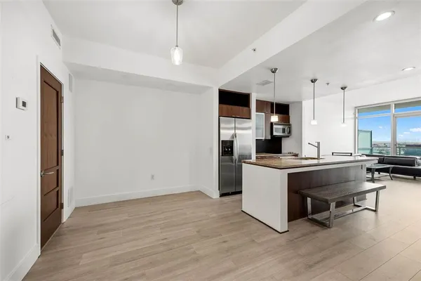 a large white kitchen with a large window and stainless steel appliances