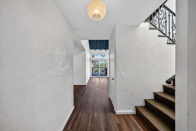 a view of a hallway with wooden floor and staircase