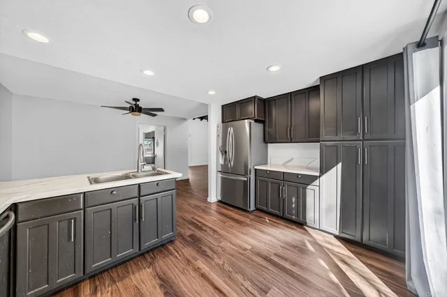 a kitchen with a sink refrigerator and cabinets