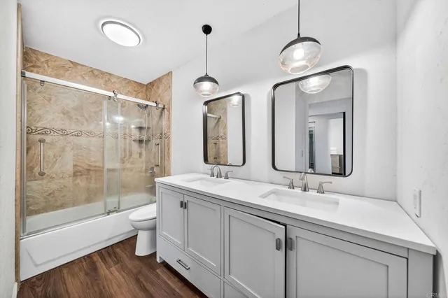 a bathroom with a double vanity sink mirror and toilet