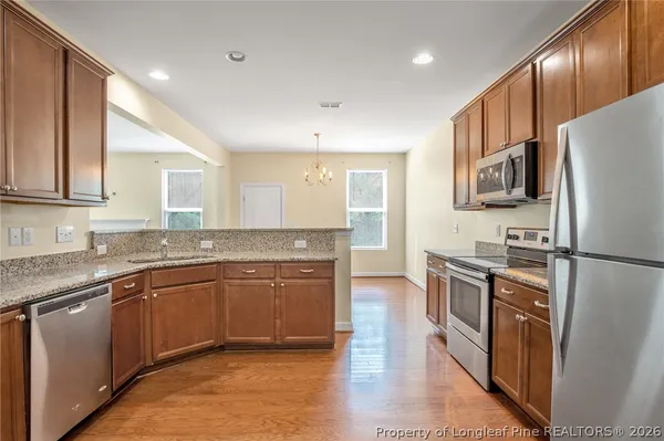 a kitchen with stainless steel appliances granite countertop a refrigerator a stove top oven a sink and dishwasher