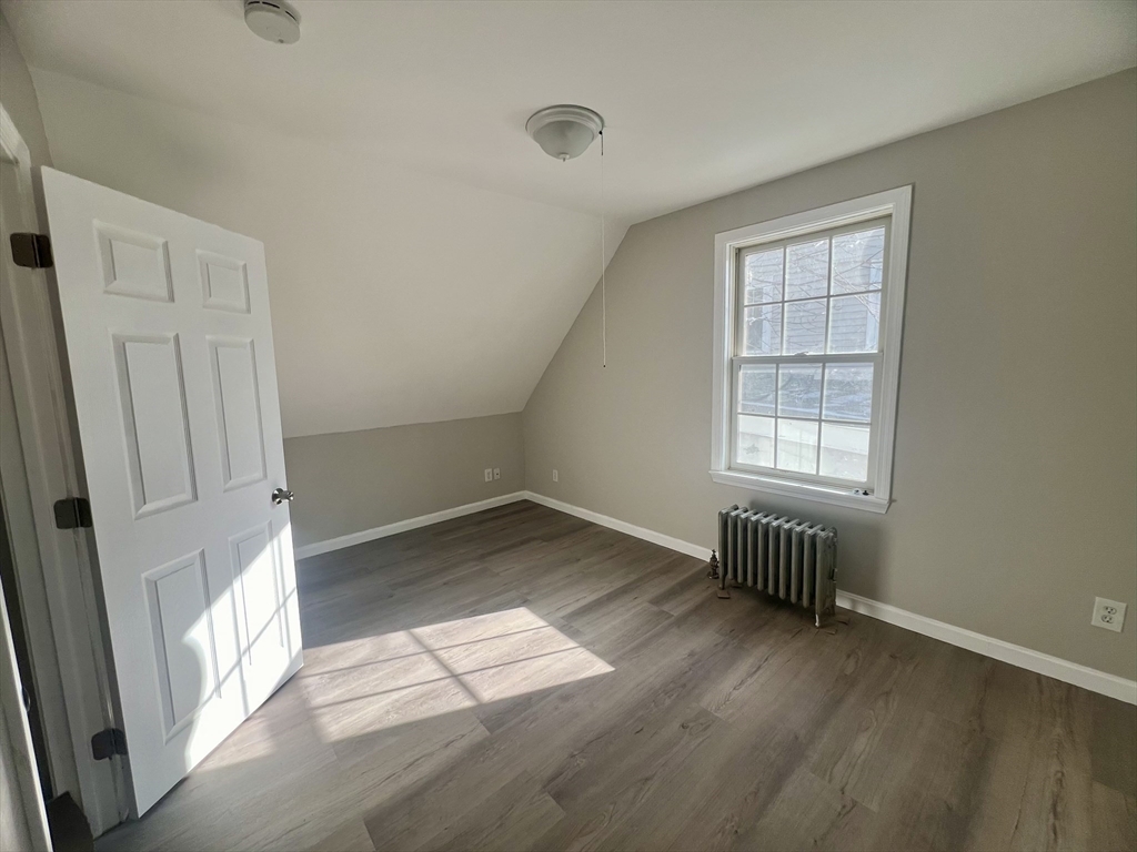 24 Proctor Street Worcester, MA 01606 - Photo 11 of 25 an empty room with wooden floor and windows