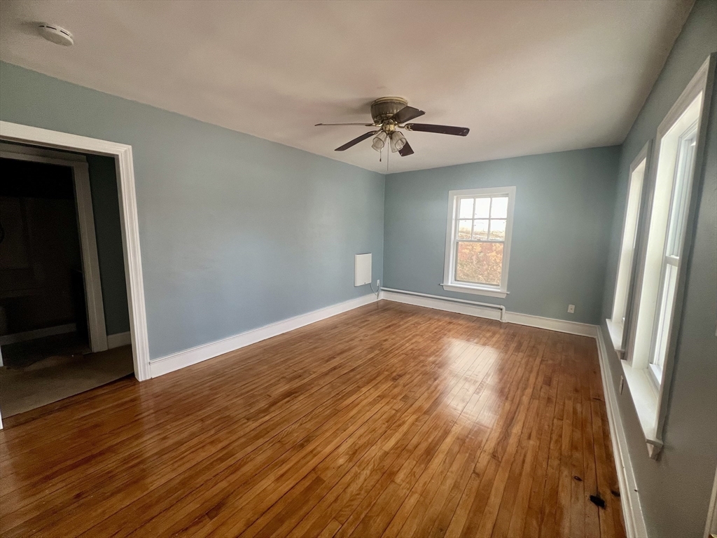24 Proctor Street Worcester, MA 01606 - Photo 16 of 25 an empty room with wooden floor and windows