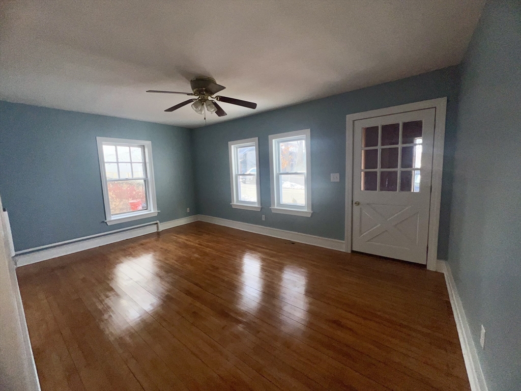 24 Proctor Street Worcester, MA 01606 - Photo 17 of 25 an empty room with wooden floor and windows