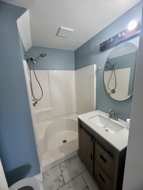 24 Proctor Street Worcester, MA 01606 - Photo 19 of 25 a bathroom with a sink mirror vanity and toilet