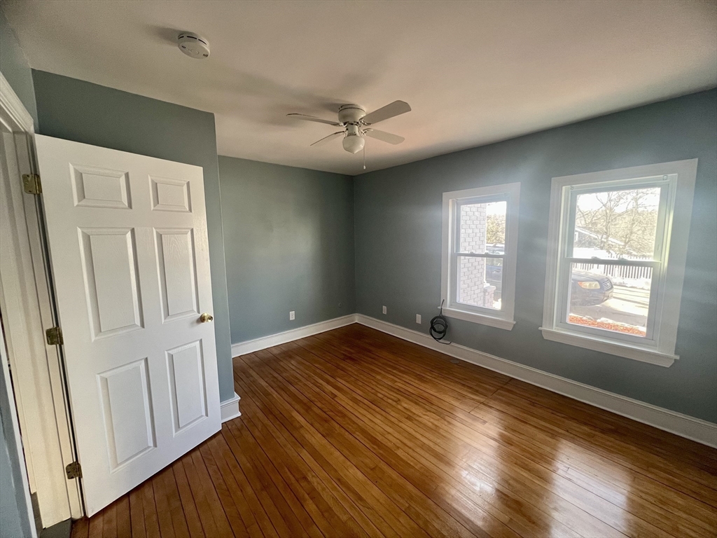 24 Proctor Street Worcester, MA 01606 - Photo 22 of 25 an empty room with wooden floor fan and windows