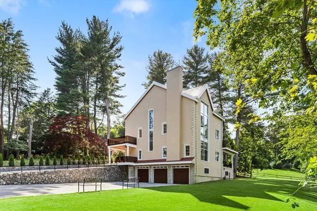 a view of a white house with a big yard and large trees