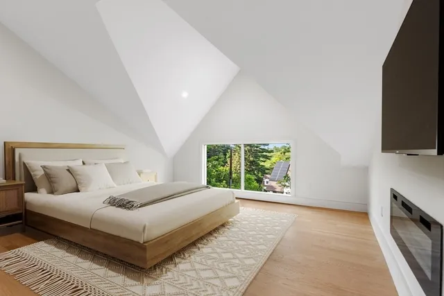 a bedroom with a large bed and a flat tv screen on dresser