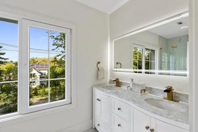 a bathroom with a granite countertop sink mirror and window