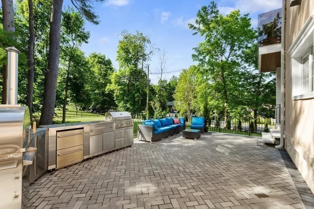 a view of a patio with table and chairs potted plants and large tree