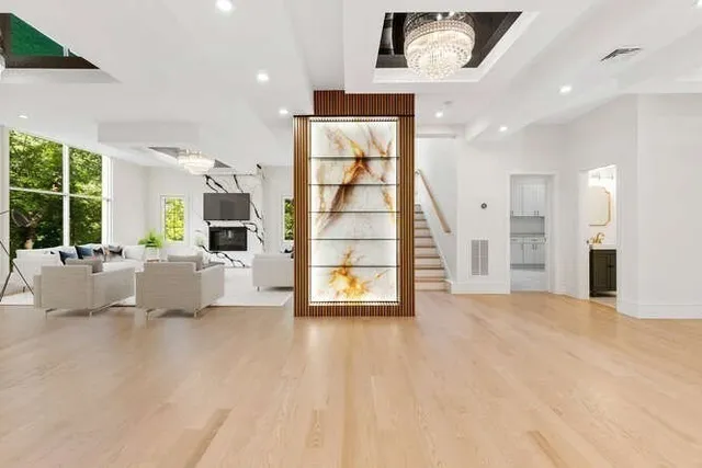 a view of an empty room with a window and a kitchen