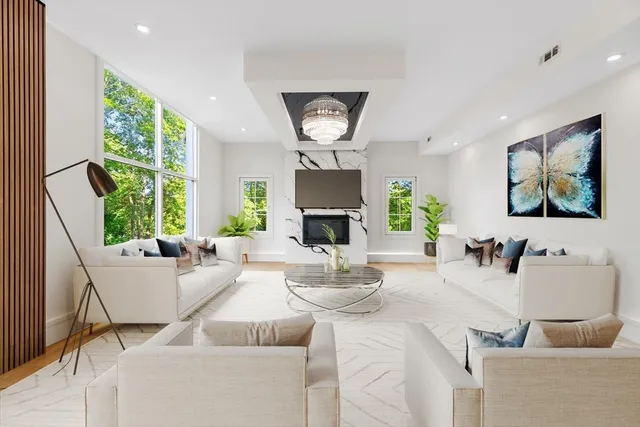 a living room with fireplace furniture and a large window