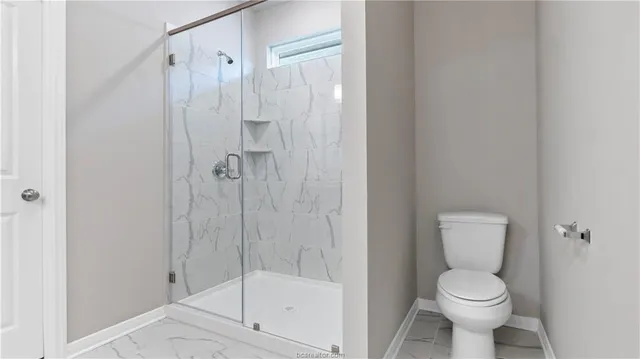 a white toilet sitting next to a bathroom