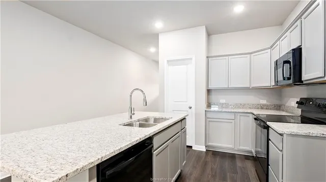 a kitchen with stainless steel appliances granite countertop a sink stove and cabinets