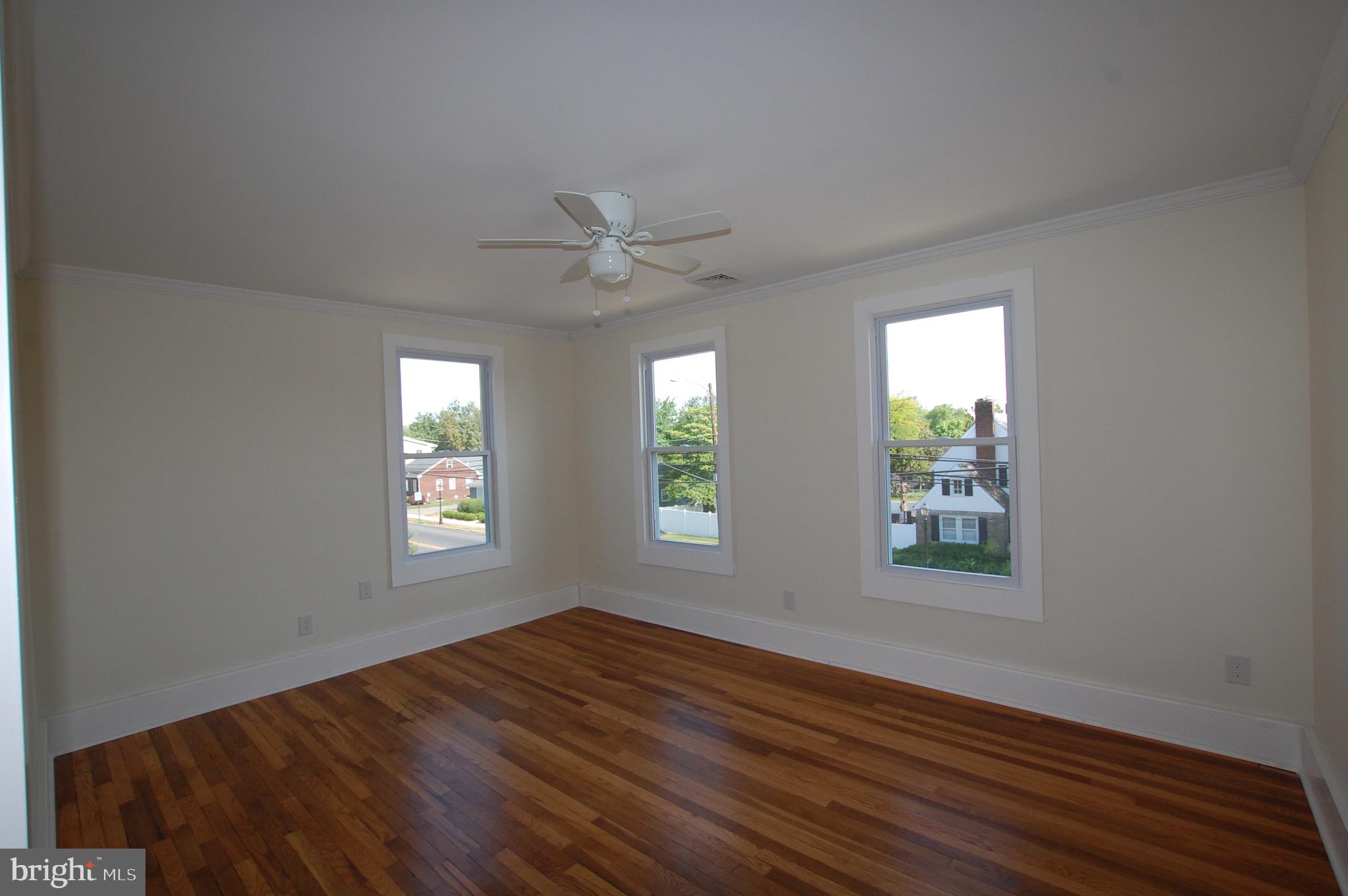 35 East Avenue, Unit 2 Woodstown, NJ 08098 - Photo 3 of 10 a view of an empty room with wooden floor and a window