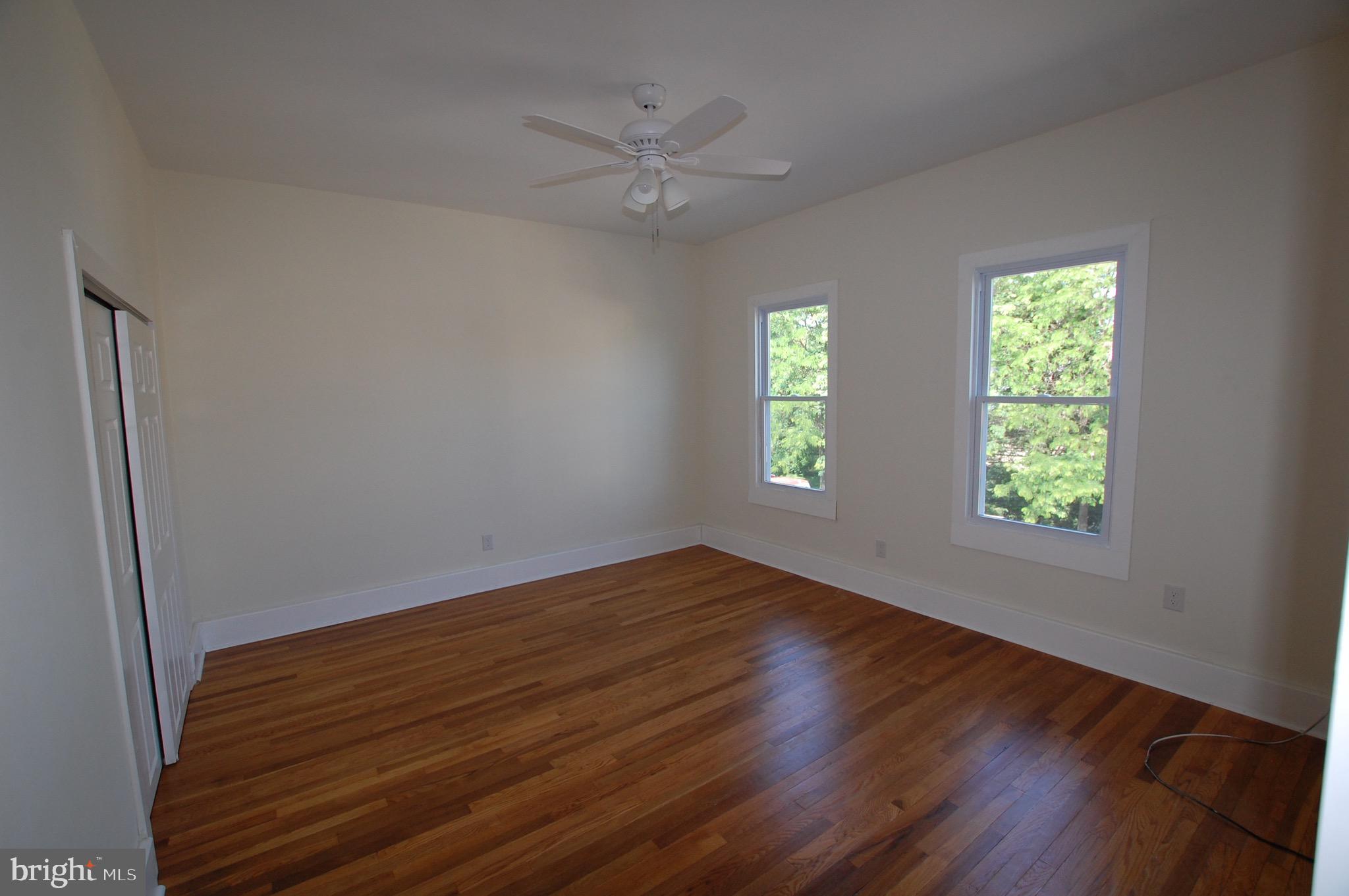 35 East Avenue, Unit 2 Woodstown, NJ 08098 - Photo 6 of 10 a view of an empty room with wooden floor and a window