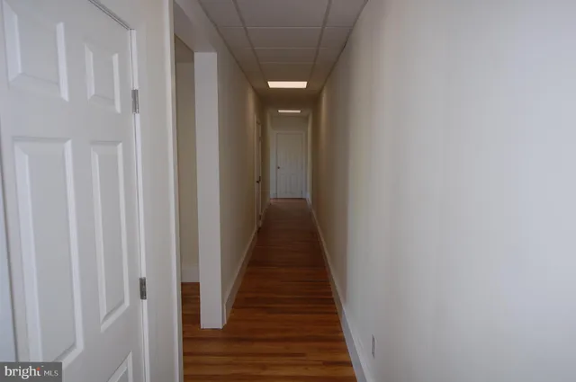 a view of a hallway with wooden floor