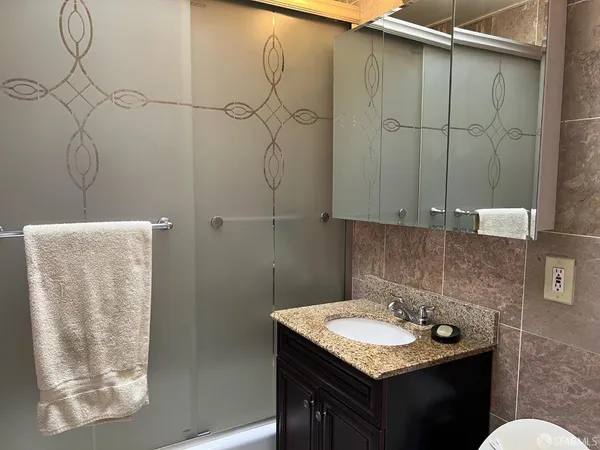 a bathroom with a granite countertop sink and a mirror