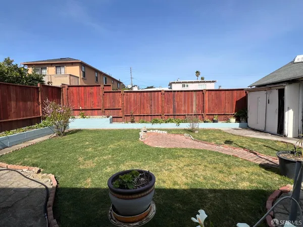 a view of a backyard with plants and patio
