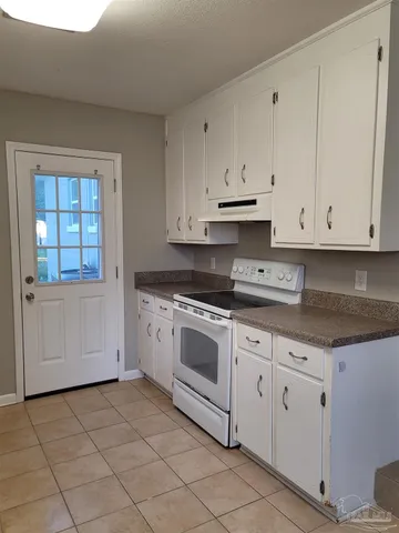 a kitchen with granite countertop white cabinets and white appliances