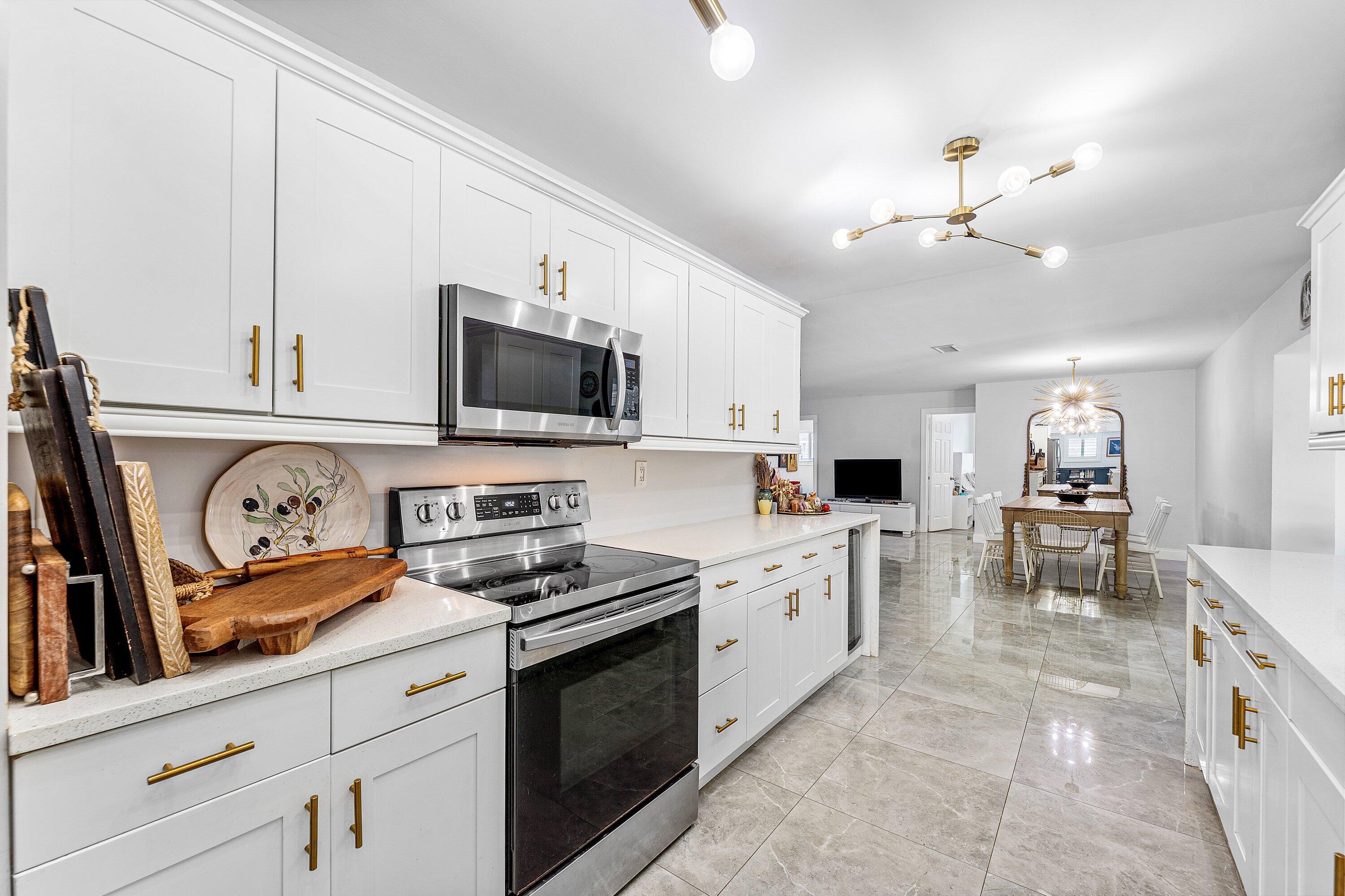 581 Northwest 13th Drive Boca Raton, FL 33486 - Photo 12 of 39 a kitchen with granite countertop a stove a sink and a microwave