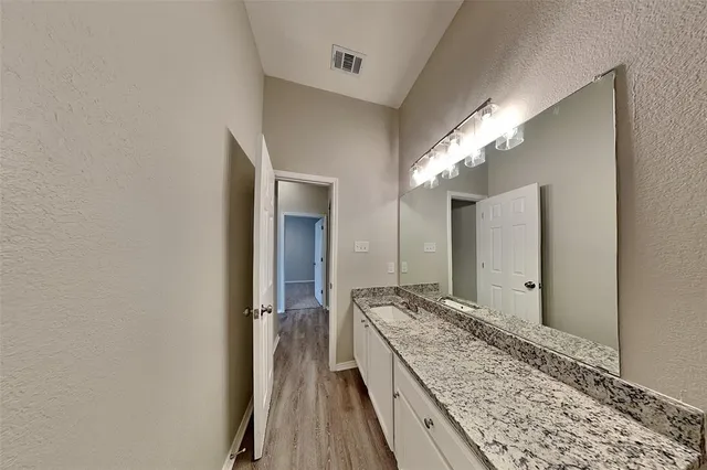 a spacious bathroom with a granite countertop sink and a mirror